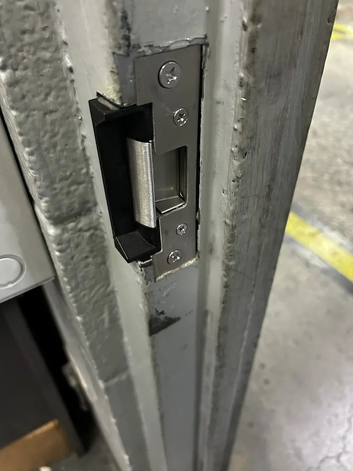 Satin stainless electric strike installed in the steel jamb, keeper and faceplate fixed with four screws