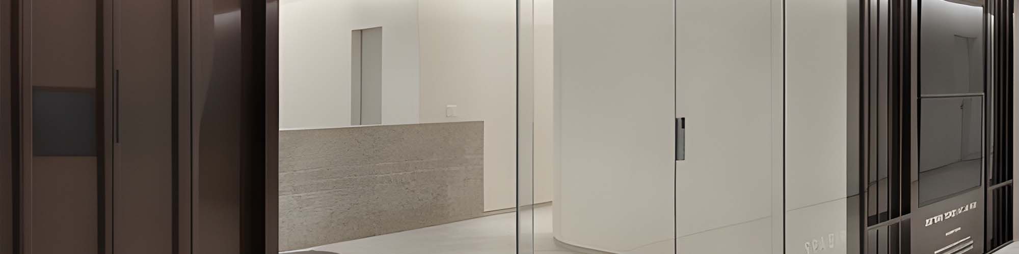 Panoramic interior view of dark wood door panels beside white curved glass wall