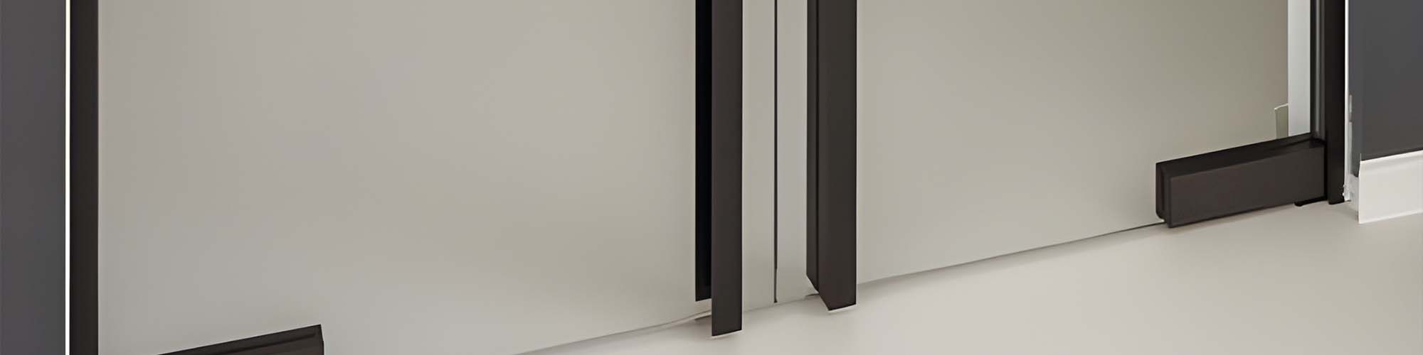 Black metal door stile and floor stop beside frosted glass partition panels