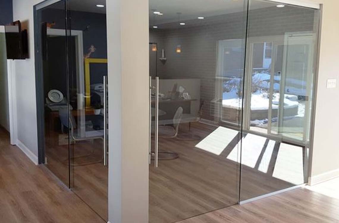 Glass office partition walls and glass doors in wood floor interior